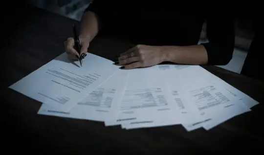 a woman sitting at a table with lots of papers